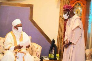 Tinubu (r) standing before the sultan